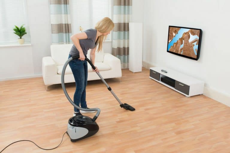 Una chica aspirando su casa