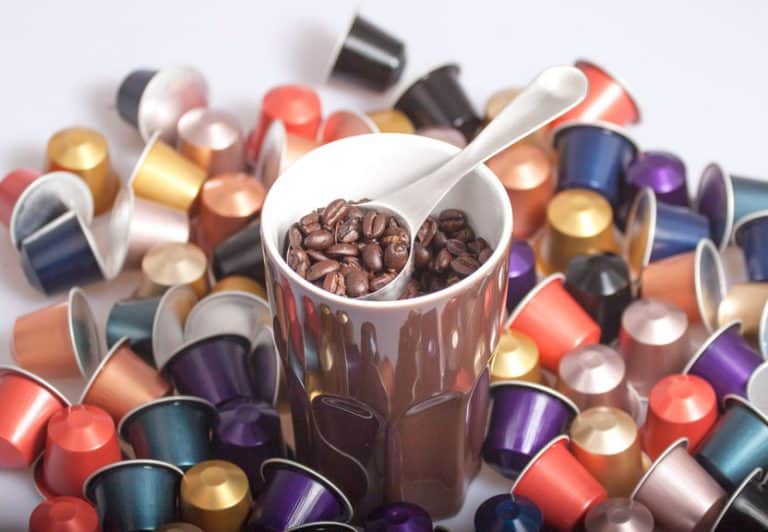 Muchas cápsulas de Nespresso con una taza