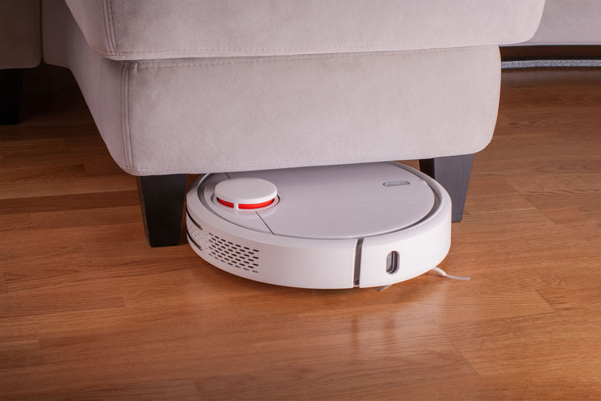 Robot vacuum cleaner runs under sofa in room