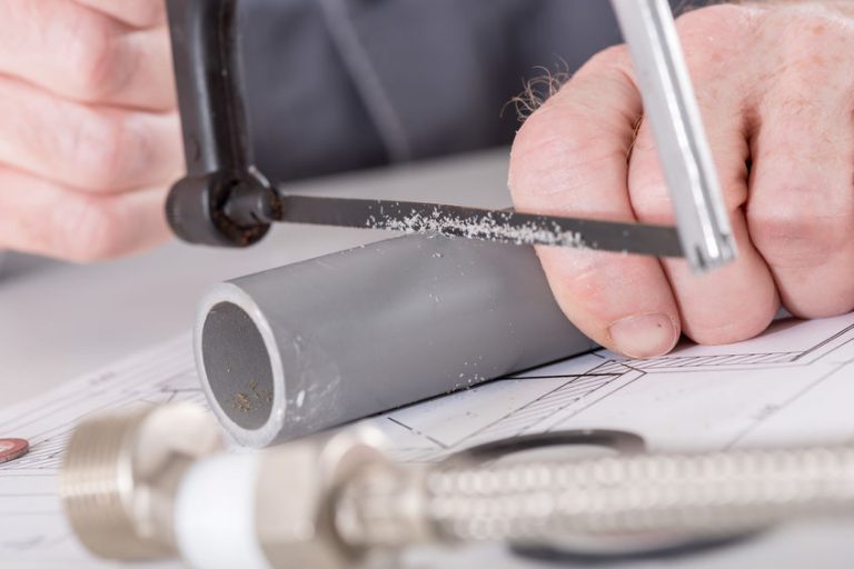 Hombre cortando tubo de plastico